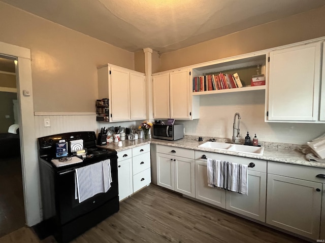1746 College Ave, Huntington, IN 46750 - kitchen featuring a sink, stainless steel microwave, black / electric stove, dark wood-style flooring, and wainscoting