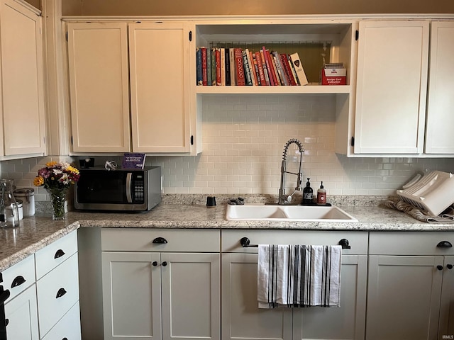 1746 College Ave, Huntington, IN 46750 - kitchen with stainless steel microwave, decorative backsplash, a sink, and open shelves