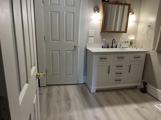 1746 College Ave, Huntington, IN 46750 - bathroom featuring wood finished floors, vanity, and baseboards