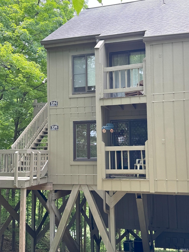 9384 S Lake Ridge Dr Unit 90, Bloomington, IN 47401 - view of home's exterior featuring stairway, roof with shingles, board and batten siding, and a balcony