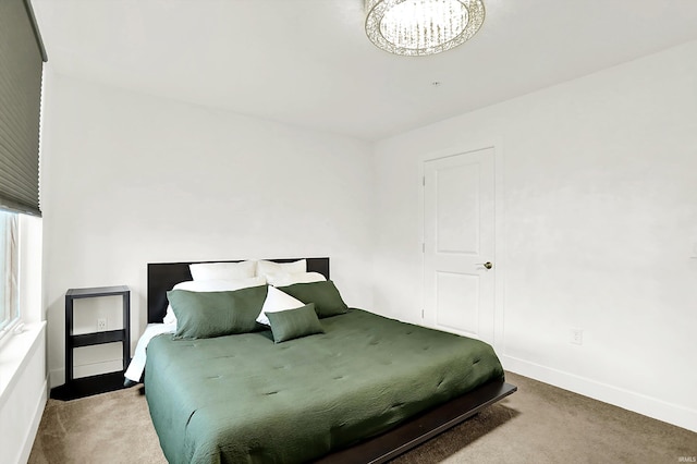304 W Kirkwood Ave Unit 203, Bloomington, IN 47404 - carpeted bedroom with a chandelier and baseboards