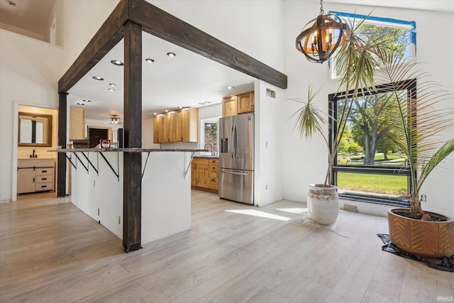 16828 Barryknoll Way, Granger, IN 46530 - kitchen featuring stainless steel fridge, a chandelier, a towering ceiling, light wood-style floors, and a sink