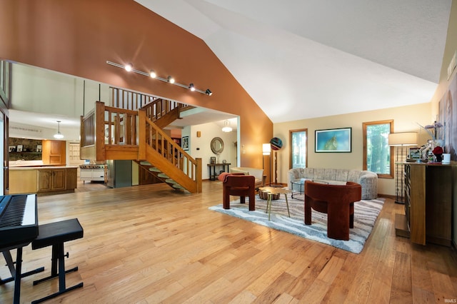 7301 W River Rd, Yorktown, IN 47396 - living area featuring high vaulted ceiling, light wood-style floors, and stairs