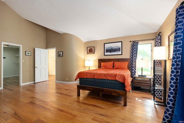 7301 W River Rd, Yorktown, IN 47396 - bedroom featuring vaulted ceiling, light wood-type flooring, baseboards, and a spacious closet