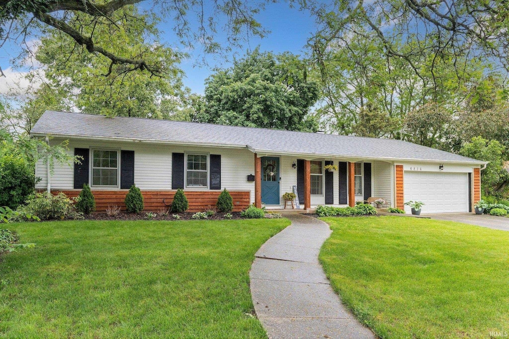 6836 Penmoken Dr, Fort Wayne, IN 46819 - ranch-style house with a porch, a front lawn, an attached garage, and asphalt driveway