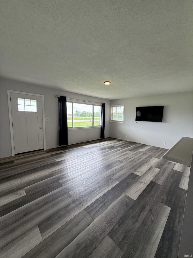 7540 S US-27 Hwy, Portland, IN 47371 - unfurnished living room featuring a textured ceiling and wood finished floors