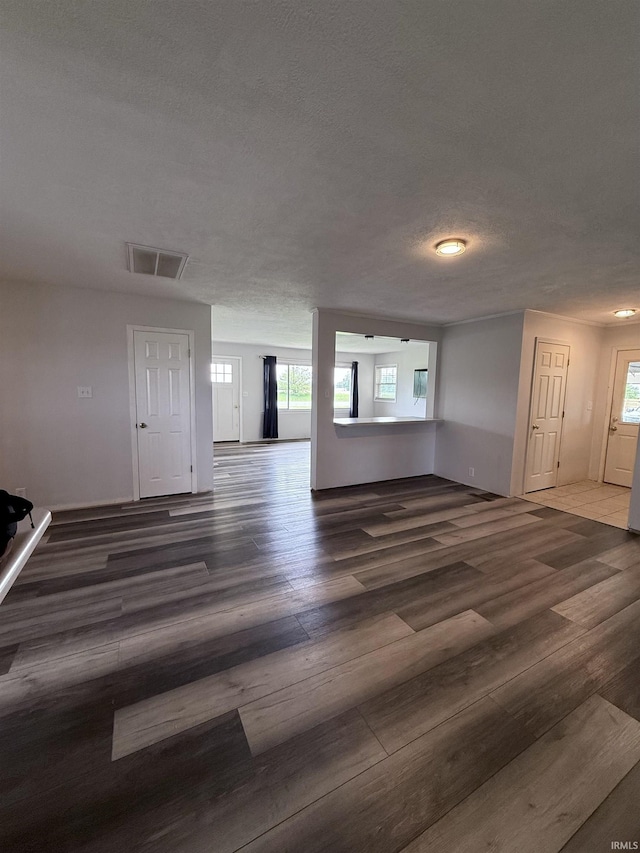 7540 S US-27 Hwy, Portland, IN 47371 - unfurnished living room featuring healthy amount of natural light, wood finished floors, and a textured ceiling