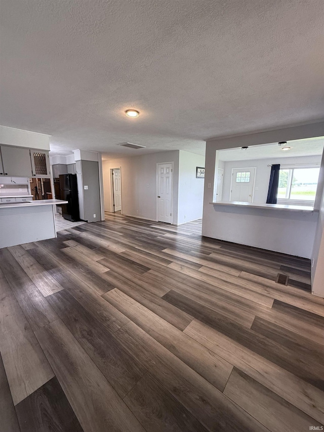 7540 S US-27 Hwy, Portland, IN 47371 - unfurnished living room with wood finished floors and a textured ceiling