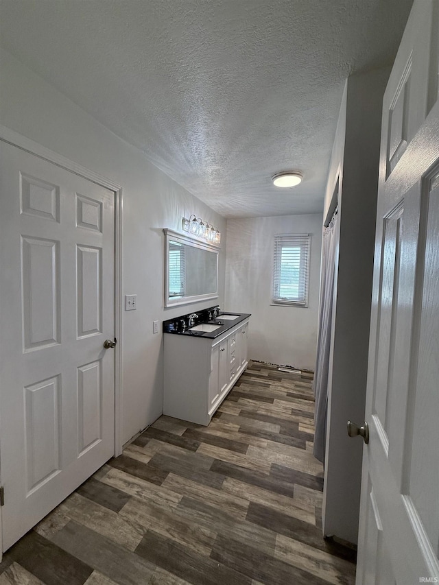 7540 S US-27 Hwy, Portland, IN 47371 - kitchen featuring a textured ceiling, dark wood-style flooring, white cabinets, and a sink