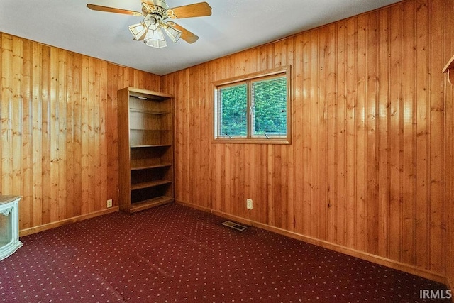 315 E Payton St, Greentown, IN 46936 - spare room with wood walls, carpet flooring, a ceiling fan, and baseboards