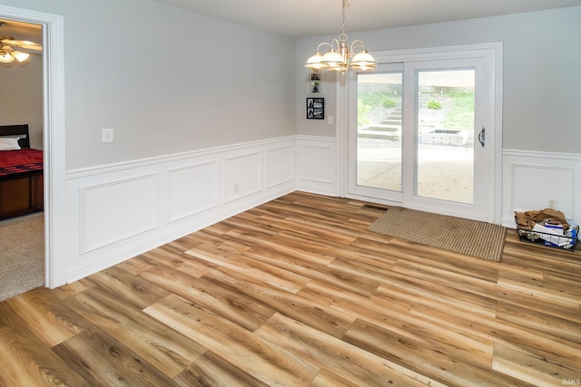 105 Temple Dr, Newburgh, IN 47630 - unfurnished dining area featuring light wood-type flooring, a wainscoted wall, a decorative wall, and a chandelier