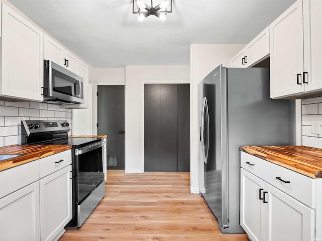 2834 Inwood Dr, Fort Wayne, IN 46815 - kitchen with wood counters, stainless steel appliances, light wood finished floors, tasteful backsplash, and white cabinets