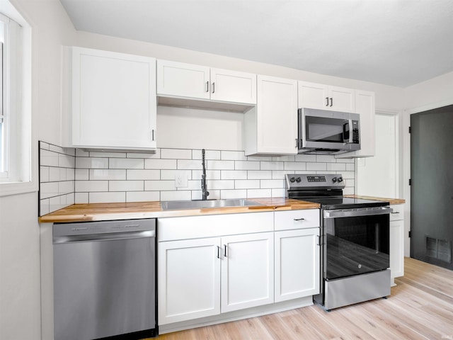 2834 Inwood Dr, Fort Wayne, IN 46815 - kitchen featuring appliances with stainless steel finishes, wooden counters, a sink, and decorative backsplash