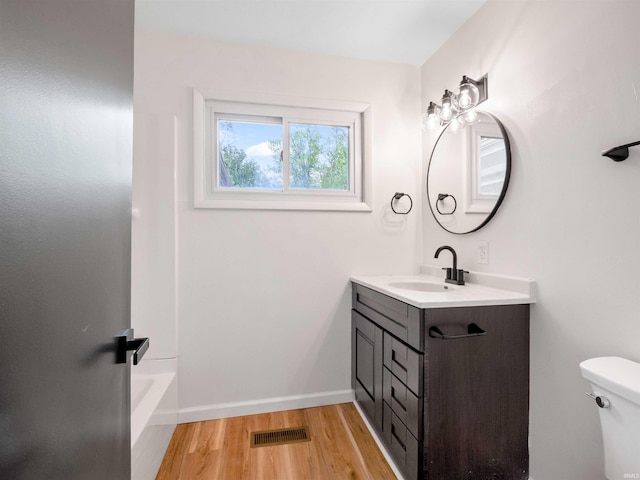 2834 Inwood Dr, Fort Wayne, IN 46815 - bathroom with vanity, toilet, wood finished floors, baseboards, and washtub / shower combination