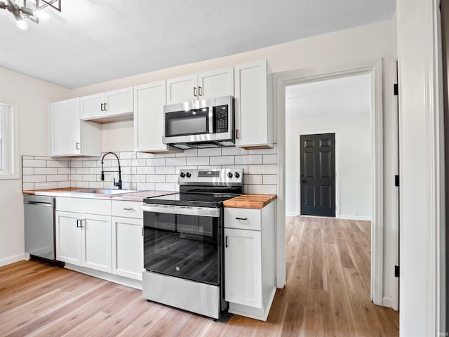 2834 Inwood Dr, Fort Wayne, IN 46815 - kitchen with appliances with stainless steel finishes, wood counters, a sink, and light wood finished floors