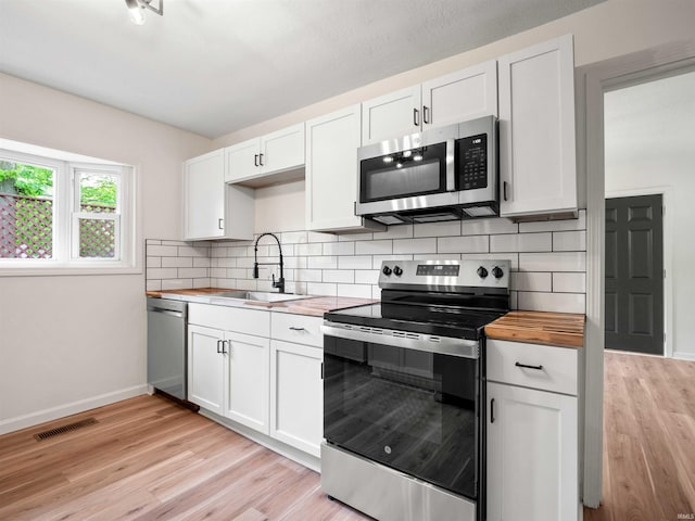 2834 Inwood Dr, Fort Wayne, IN 46815 - kitchen with appliances with stainless steel finishes, wood counters, a sink, and light wood finished floors