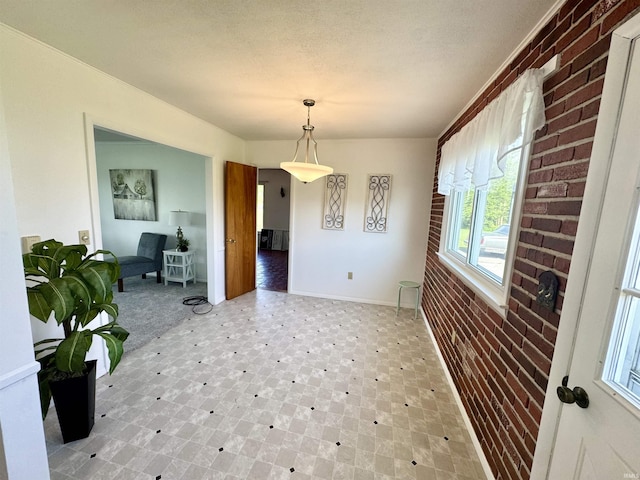 10908 Kathy Dr, Fort Wayne, IN 46835 - unfurnished dining area featuring light floors, baseboards, and brick wall