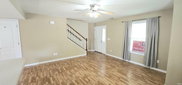 1250 W Adams Hill Cir Unit 401, Bloomington, IN 47403 - spare room with light wood-style flooring, stairs, baseboards, and a ceiling fan
