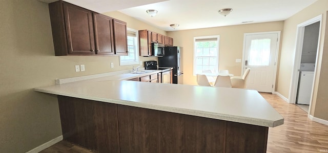 1250 W Adams Hill Cir Unit 401, Bloomington, IN 47403 - kitchen featuring stainless steel microwave, light countertops, baseboards, and light wood-type flooring