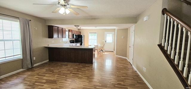 1250 W Adams Hill Cir Unit 401, Bloomington, IN 47403 - kitchen with wood finished floors, a peninsula, freestanding refrigerator, light countertops, and ceiling fan