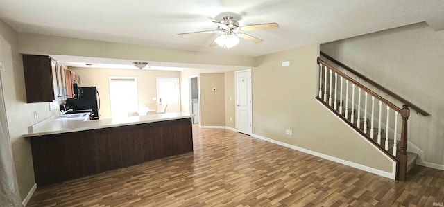 1250 W Adams Hill Cir Unit 401, Bloomington, IN 47403 - kitchen featuring wood finished floors, ceiling fan, freestanding refrigerator, light countertops, and a peninsula