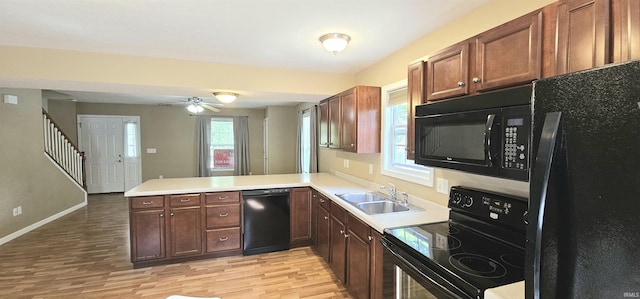 1250 W Adams Hill Cir Unit 401, Bloomington, IN 47403 - kitchen with black appliances, a sink, a peninsula, and light wood finished floors