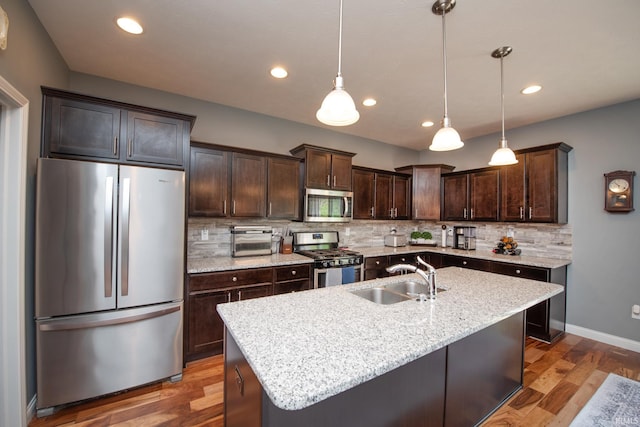 6336 Munsee Dr, West Lafayette, IN 47906 - kitchen with stainless steel appliances, a sink, dark brown cabinets, tasteful backsplash, and wood finished floors