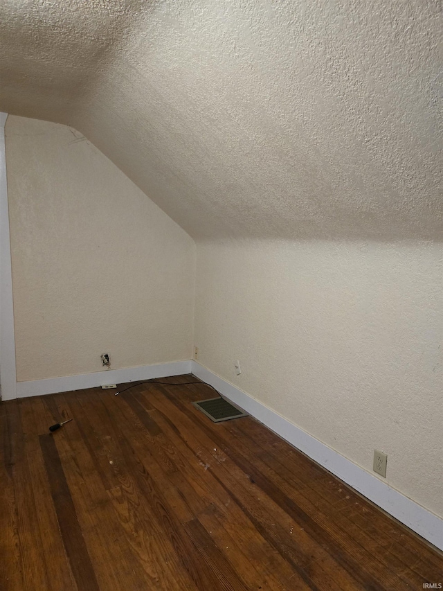 910 Ridgeway Ave, Vincennes, IN 47591 - additional living space with baseboards, dark wood-style flooring, vaulted ceiling, and a textured ceiling