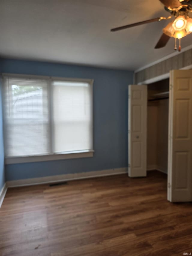 910 Ridgeway Ave, Vincennes, IN 47591 - unfurnished bedroom featuring multiple windows, dark wood-type flooring, and a closet