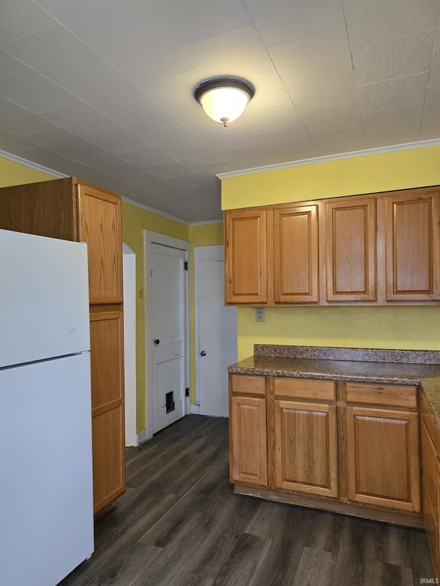 910 Ridgeway Ave, Vincennes, IN 47591 - kitchen featuring freestanding refrigerator, dark countertops, brown cabinets, and crown molding