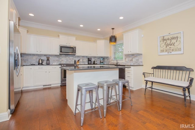 4288 Windhill Ln, Newburgh, IN 47630 - kitchen with appliances with stainless steel finishes, dark countertops, dark wood finished floors, ornamental molding, and a breakfast bar area