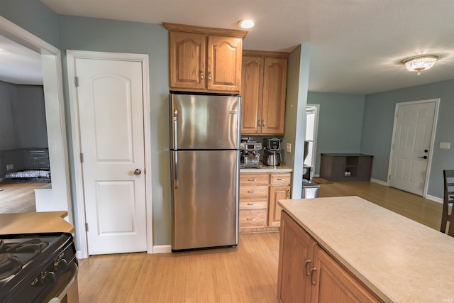 5212 E 600 S, Lafayette, IN 47909 - kitchen featuring stainless steel appliances, light wood-style floors, light countertops, baseboards, and brown cabinetry