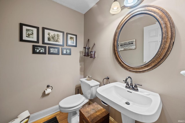 2525 Hastye Hyll, Logansport, IN 46947 - half bathroom featuring baseboards, toilet, a sink, and wood finished floors