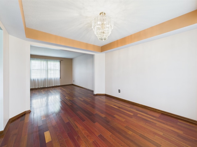3715 W 630 Rd N, Huntington, IN 46750 - unfurnished room featuring a chandelier, baseboards, dark wood-style floors, and a tray ceiling