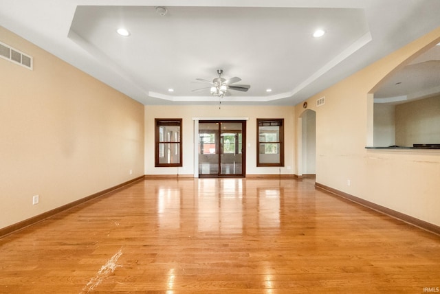 2395 S 400 St W, Warsaw, IN 46580 - unfurnished living room featuring a raised ceiling, arched walkways, light wood-style floors, ceiling fan, and recessed lighting