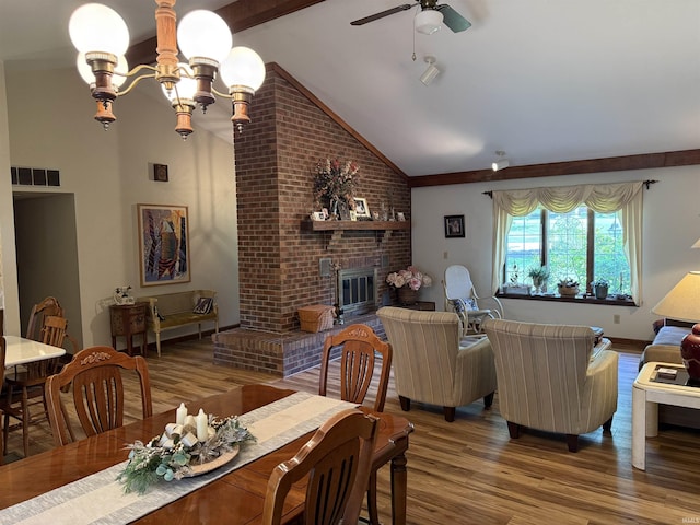 2807 Avondale Rd, Vincennes, IN 47591 - dining area featuring wood finished floors, vaulted ceiling, a ceiling fan, a brick fireplace, and a chandelier