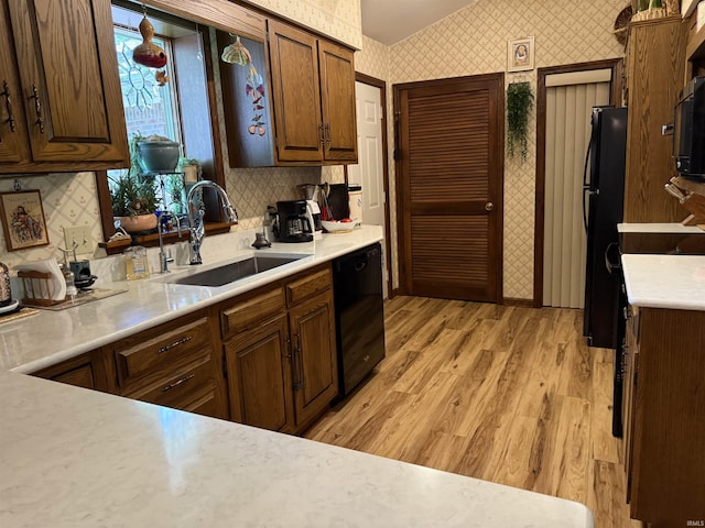 2807 Avondale Rd, Vincennes, IN 47591 - kitchen with wallpapered walls, black appliances, a sink, light countertops, and light wood-style floors