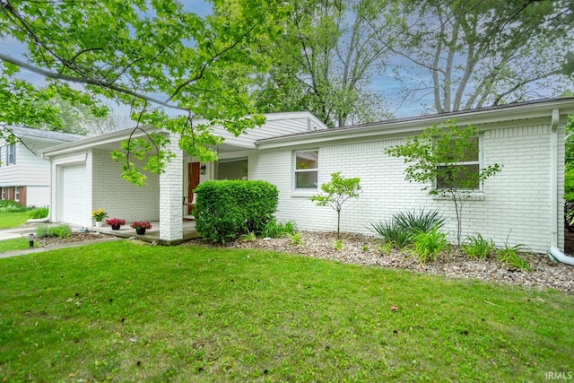 704 Avondale St, West Lafayette, IN 47906 - view of property exterior with an attached garage, a yard, and brick siding