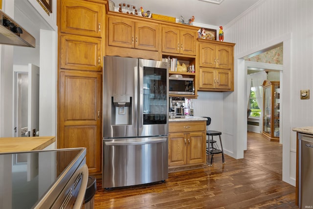 702 S Van Buren St, Auburn, IN 46706 - kitchen featuring appliances with stainless steel finishes, dark wood-type flooring, crown molding, brown cabinets, and wall chimney exhaust hood