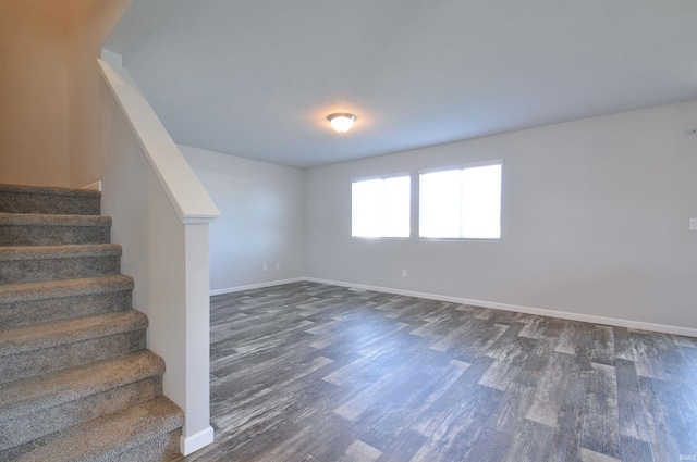 409 W Somerfield Dr, Lakeville, IN 46536 - spare room featuring stairs, dark wood-type flooring, and baseboards