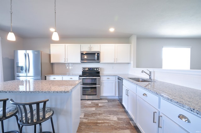409 W Somerfield Dr, Lakeville, IN 46536 - kitchen featuring stainless steel appliances, a sink, white cabinets, wood finished floors, and recessed lighting