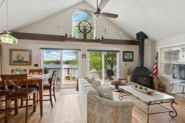 5585 S 930 E, Wolcottville, IN 46795 - living room featuring high vaulted ceiling, ceiling fan, a textured ceiling, light wood finished floors, and a wood stove