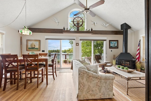 5585 S 930 E, Wolcottville, IN 46795 - living room featuring a textured ceiling, light wood-type flooring, a ceiling fan, high vaulted ceiling, and a wood stove