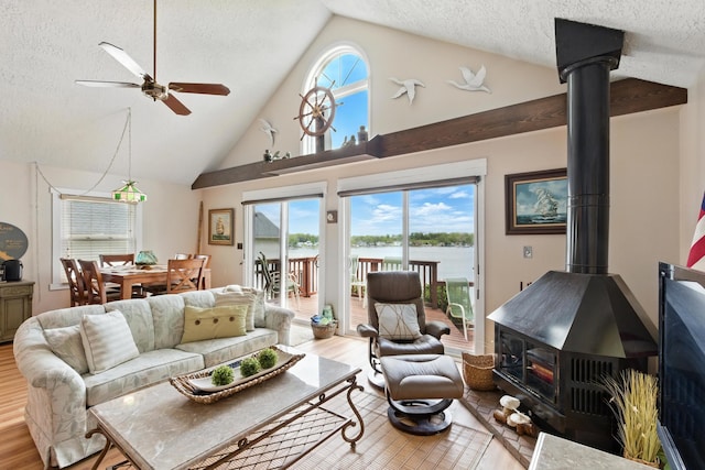 5585 S 930 E, Wolcottville, IN 46795 - living area with a wood stove, wood finished floors, a textured ceiling, ceiling fan, and healthy amount of natural light