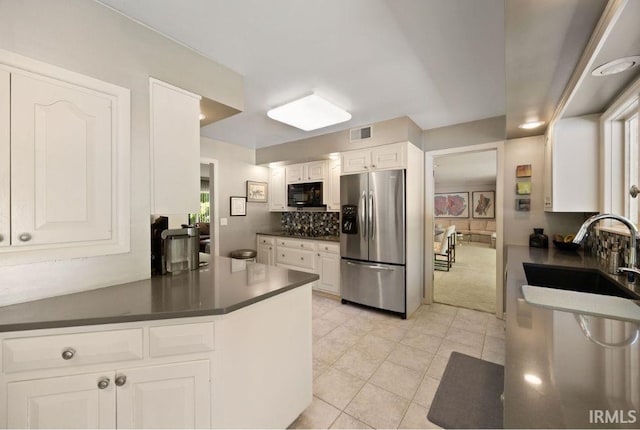 570 Golden Pl, Lafayette, IN 47905 - kitchen featuring stainless steel refrigerator with ice dispenser, black microwave, dark countertops, white cabinets, and tasteful backsplash