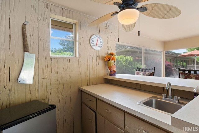 570 Golden Pl, Lafayette, IN 47905 - kitchen featuring a sink, healthy amount of natural light, light countertops, wood walls, and ceiling fan