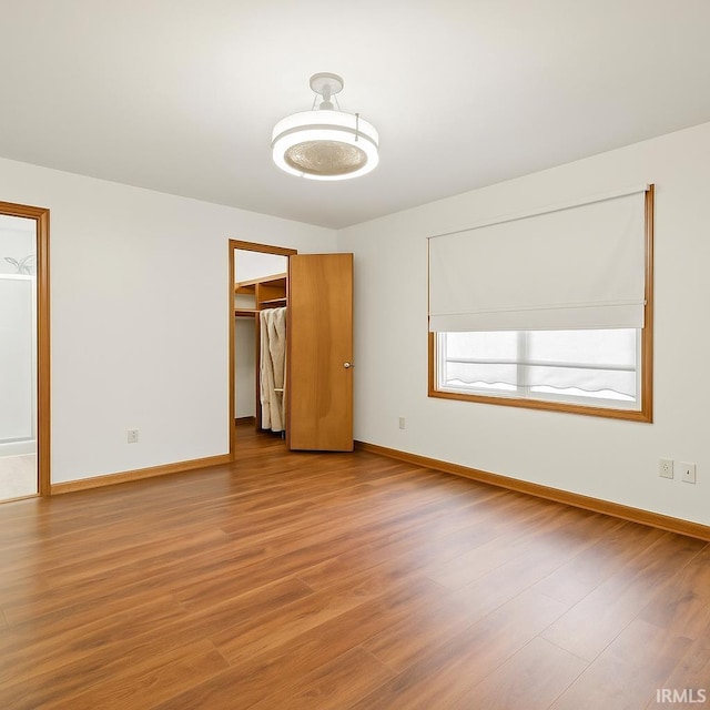 951 W Shepherds Ln, Santa Claus, IN 47579 - unfurnished bedroom with baseboards, a spacious closet, wood finished floors, and a closet
