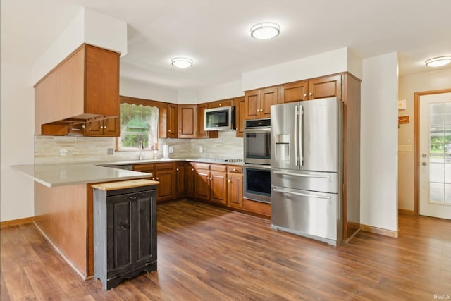 951 W Shepherds Ln, Santa Claus, IN 47579 - kitchen with stainless steel appliances, a peninsula, light countertops, backsplash, and dark wood-type flooring