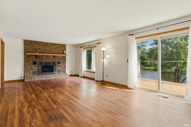 951 W Shepherds Ln, Santa Claus, IN 47579 - unfurnished living room with wood finished floors, baseboards, a fireplace, and a water view