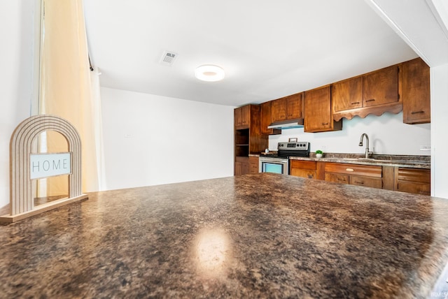 730 E Sherman St, Marion, IN 46952 - kitchen with stainless steel range with electric stovetop, under cabinet range hood, a sink, and brown cabinets